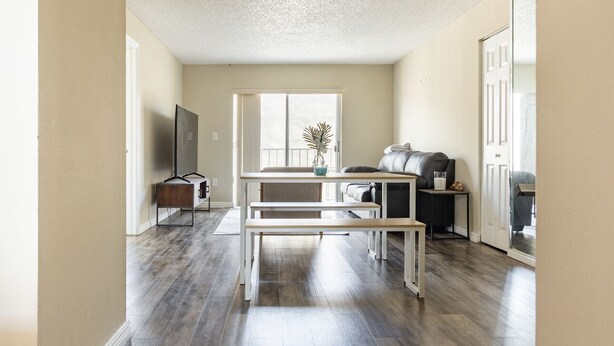 Un salon avec un canapé, une table basse, un téléviseur et une plante.