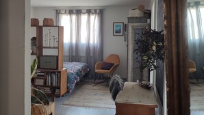 Een kamer met een bed, bureau, stoel en een boekenkast.
