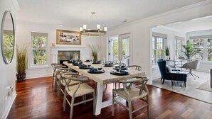 A dining area with a long wooden table set for six, surrounded by chairs. - Large Peaceful Home | Hot Tub, Dock Near Beach (Savannah)