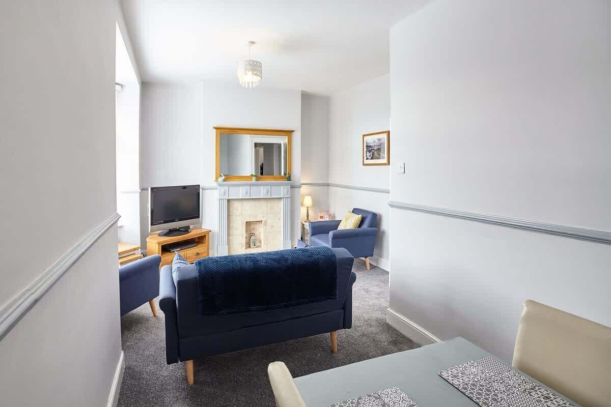 A modern living room with a fireplace, a television, and a dining area with a table and chairs.