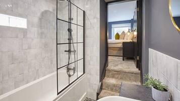 Bathtub, hair dryer, towels, shampoo