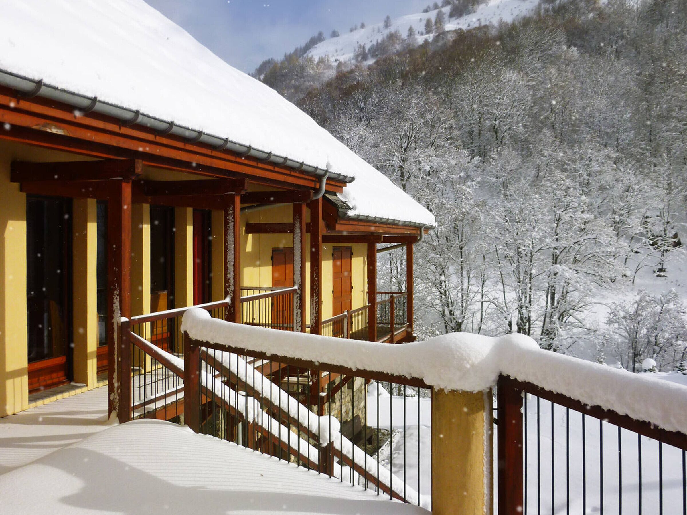 Un edificio imbiancato dalla neve con una scala in legno che conduce a un balcone.