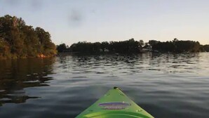 A kayak on calm water with a forested shoreline in the background. - Quaint room overlooking the lake called   Hummingbird Haven - Curriers Lakeview (Rice Lake)