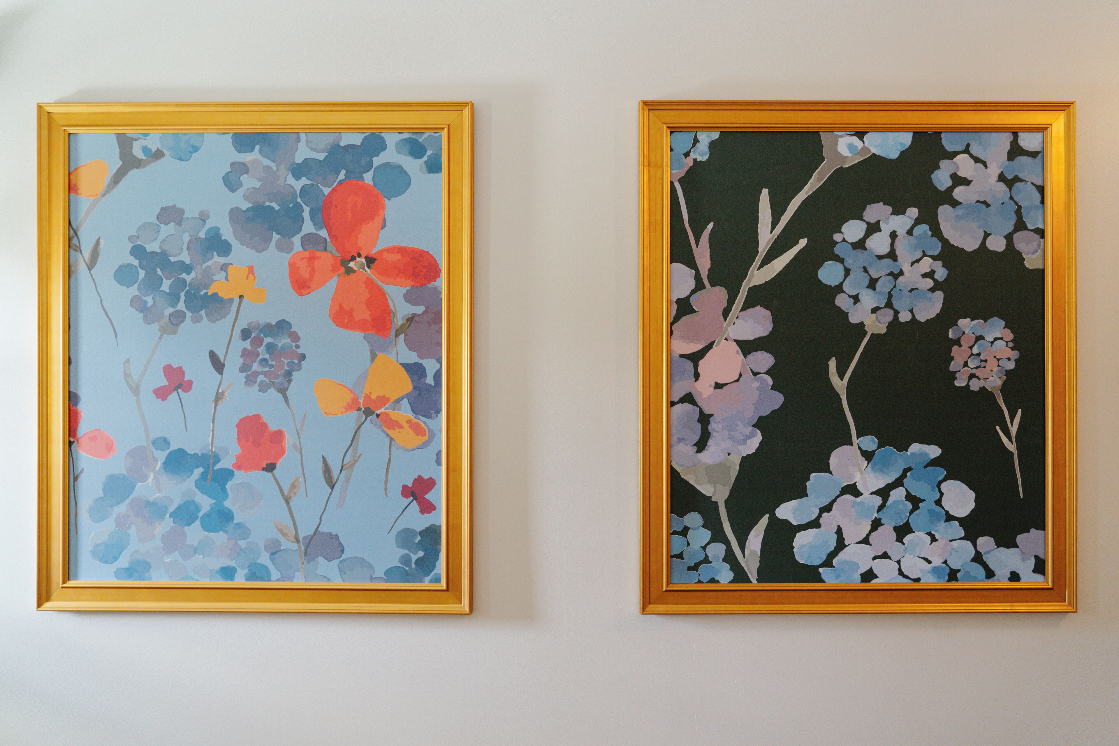 Deux tableaux représentant des motifs floraux, encadrés, sont accrochés au mur.