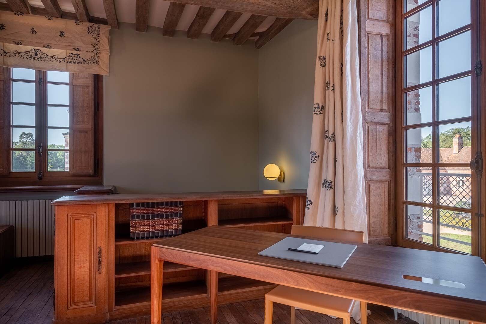 Ein Holztisch mit einem Laptop, einer gepolsterten Bank und einer Heizung.