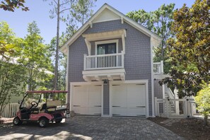 A two-story house with a balcony, a garage, and a driveway. - Luxury Forest District Retreat with Private Pool, LSV, and Resort Amenities (Santa Rosa Beach)