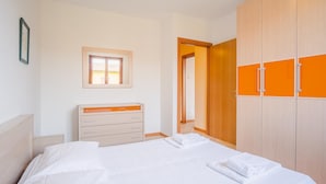 A bedroom with a bed, a dresser, and a wardrobe. - Garda Orange Apartment - Italian Homing (Desenzano del Garda)