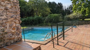A swimming pool with a stone wall and tiled deck. - Country property (Les Essarts-lès-Sézanne)
