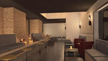 A modern lounge area with seating and tables, brick walls, and ambient lighting.