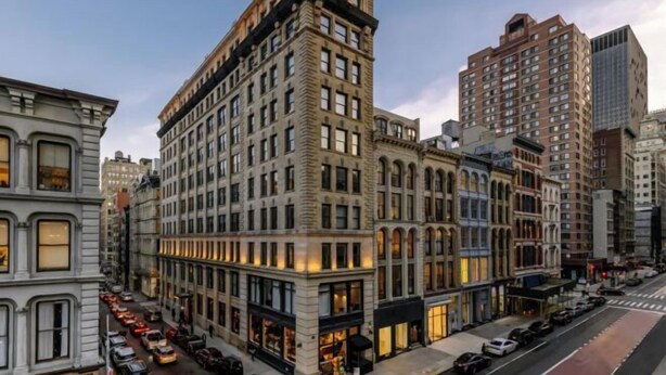 A multi-story building with a classic architectural style, featuring large windows and a corner entrance.