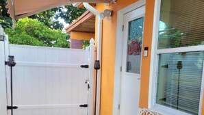 A patio with a white bench, a white fence, and a door with a window. - studio cross the street to Freedom Park Miami 3 minutes from Miami Int Airport (Miami)