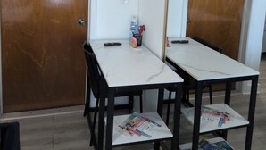 A room with two wooden doors, a white wall, a TV mounted on the wall, and a table with magazines and a remote control. - studio cross the street to Freedom Park Miami 3 minutes from Miami Int Airport (Miami)