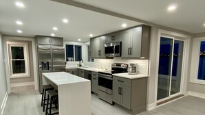 Una cocina moderna con una isla central, electrodomésticos de acero inoxidable y mucho espacio en la encimera.