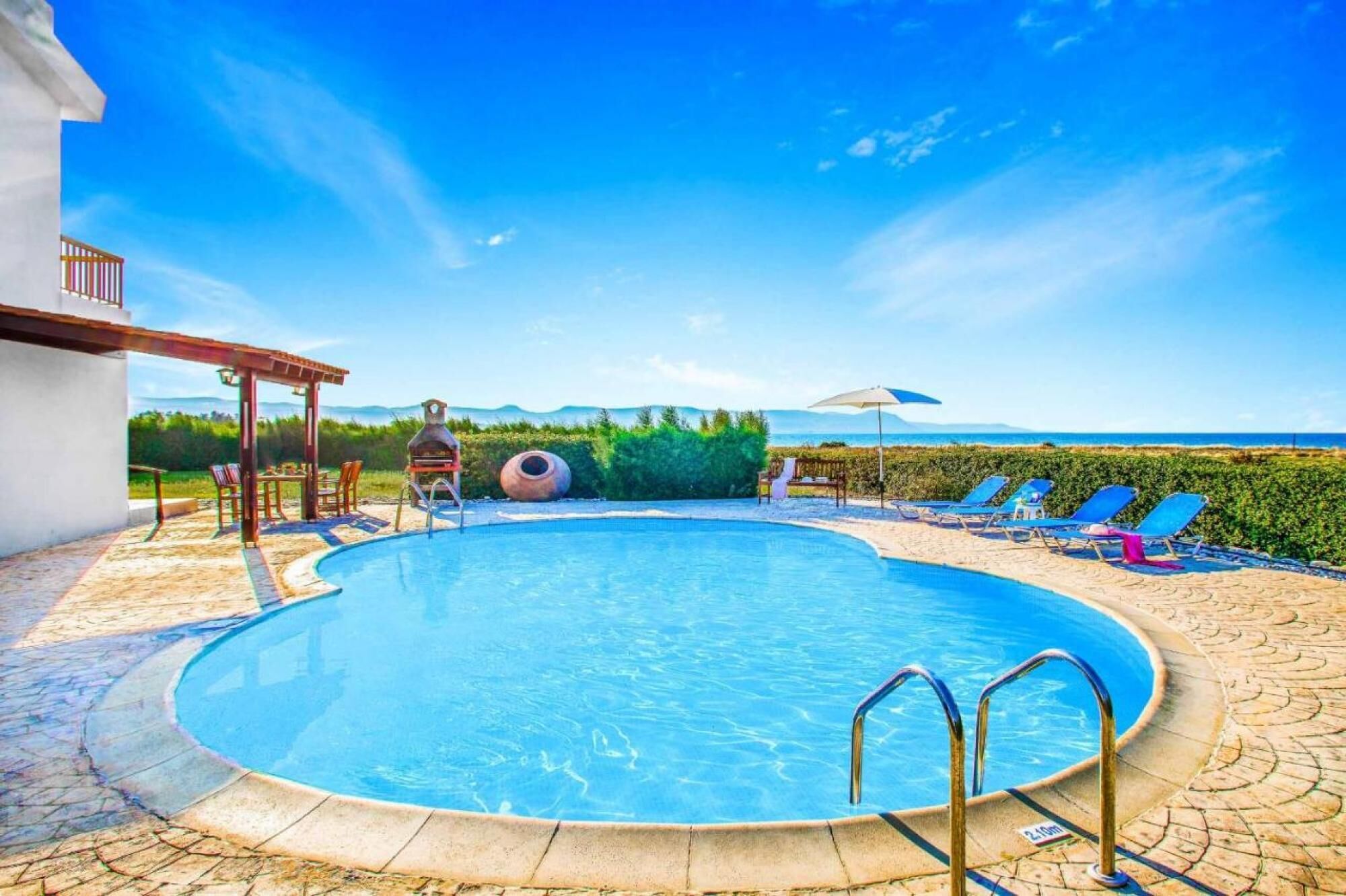 A circular swimming pool with a clear blue sky and distant mountains.