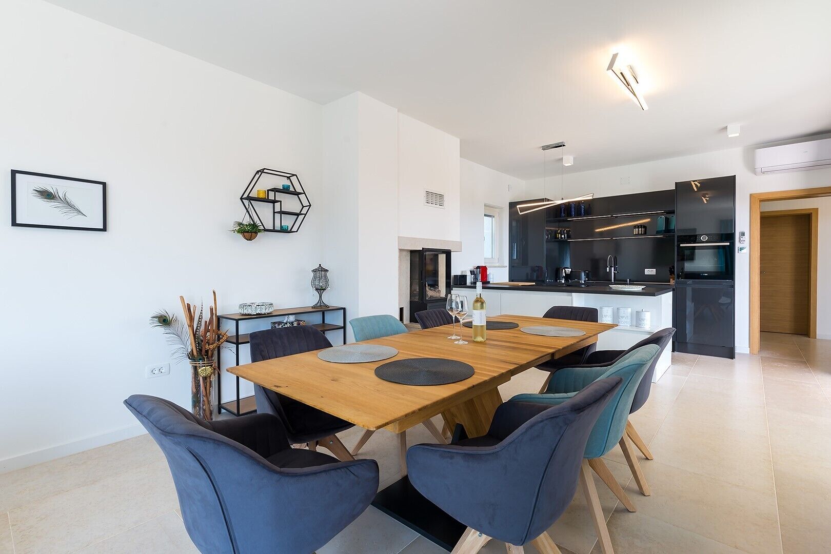 Une cuisine moderne avec des meubles de rangement noirs et un four encastré.