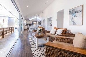 A spacious living area with a sofa, coffee table, and wicker furniture.