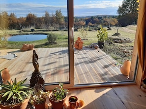 Um deck de madeira com vista para um lago e árvores.
