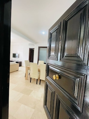 Relax in this stylish living room with a sofa, dining table, and flat-screen TV.