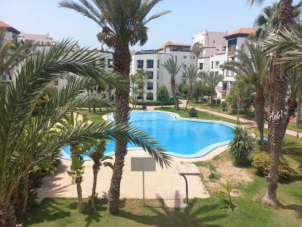 Relax by the central pool surrounded by lush palm trees and beautifully manicured lawns.