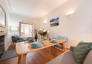 Enjoy meals in this elegant dining area with a table for four, vase, and artwork.