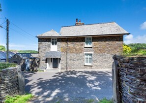 Traditional stone-built house with a central entrance and small porch area.