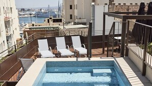 A rooftop pool with lounge chairs, a view of the marina, and buildings in the background. - Joe´s Gomila Boutique Hotel (Palma)