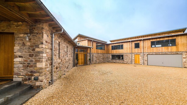 A building with a stone facade, wooden exterior, and a gravel courtyard. - Cosy countryside retreat, edge of Frome near Bath. Pets welcome. (Mells, Frome)