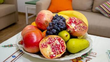 Un frutero sobre una mesa con mantel estampado.
