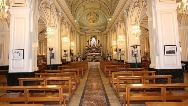 A church interior with rows of wooden pews, a marble floor, and ornate chandeliers. - Casa Mariagrazia-Etna House Mare Presa-Piedimonte (Presa)