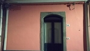 A building entrance with a numbered door, a stone archway, and a small window above the door. - Casa Mariagrazia-Etna House Mare Presa-Piedimonte (Presa)