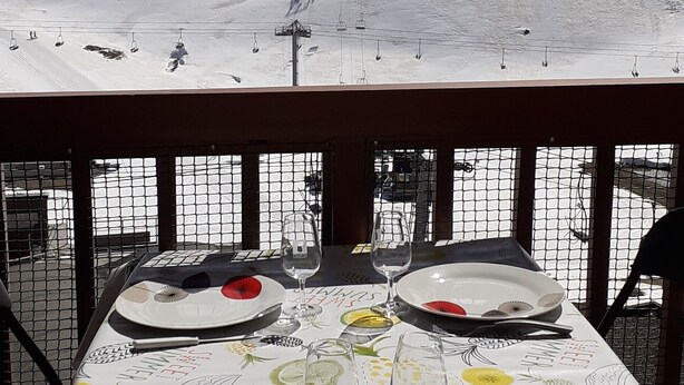 Mesa lista para comer con vistas a un telesilla y un paisaje nevado.