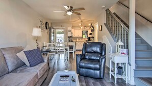 A spacious living room with a leather chair, a gray sofa, and a dining area in the background. - Pool Access, Near Beach! Waterfront Ocean City Gem (Ocean City)