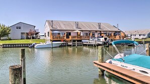 A marina with docked boats, a wooden pier, and a building with a deck. - Pool Access, Near Beach! Waterfront Ocean City Gem (Ocean City)