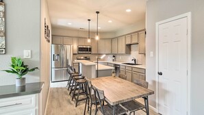 A modern kitchen with a central island, stainless steel appliances, and pendant lighting. - Pet-Friendly Houston Townhome w/ Fenced Yard (Houston)