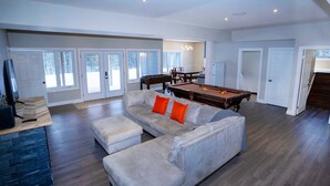 A spacious living area with a pool table, a sofa set, and a dining table. - Modern Mountain House in the Heart of Haliburton, Mins to Lake (Dysart et al)