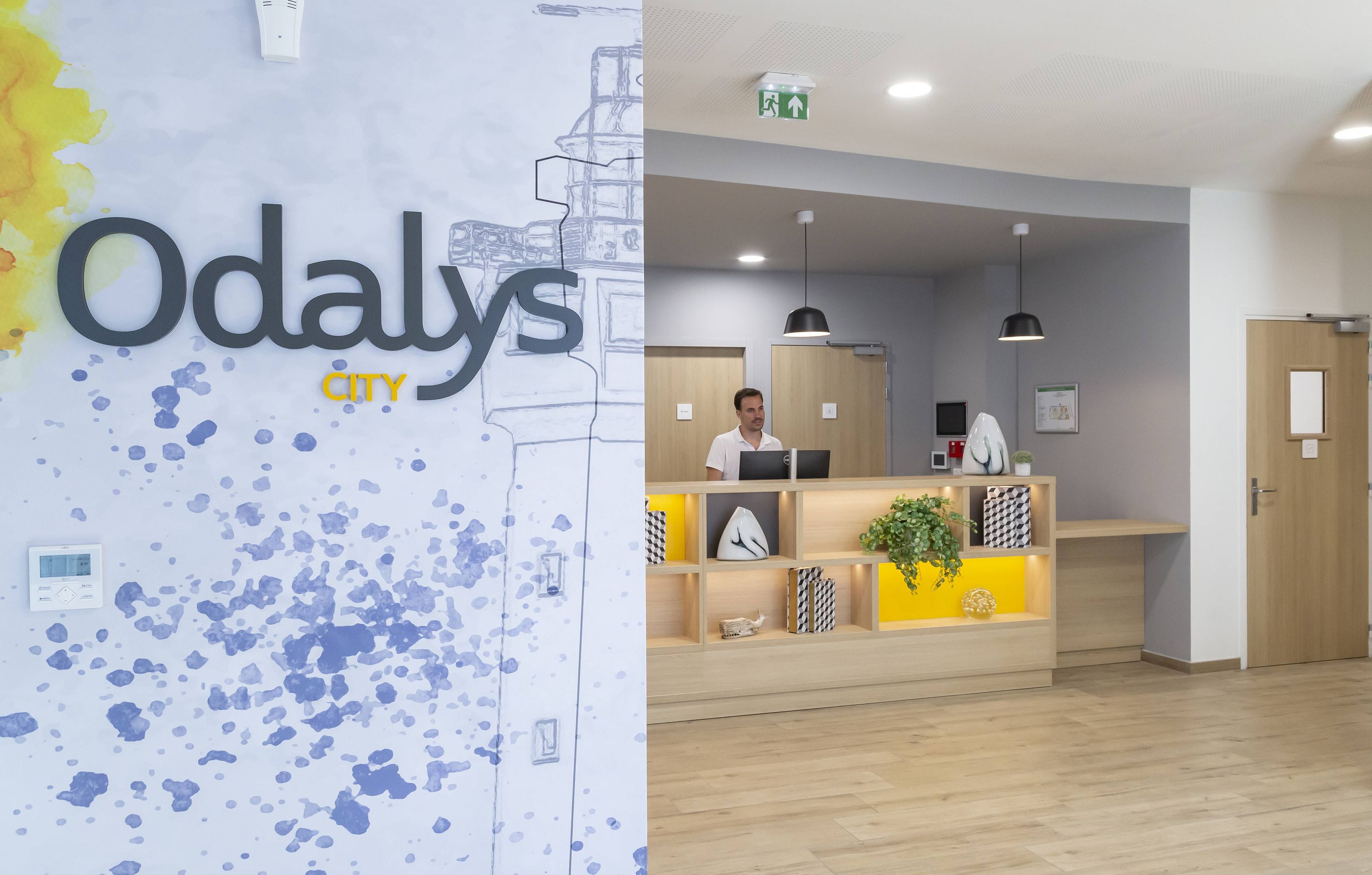 Una recepción con diseño moderno, una pantalla digital y una planta en maceta.
