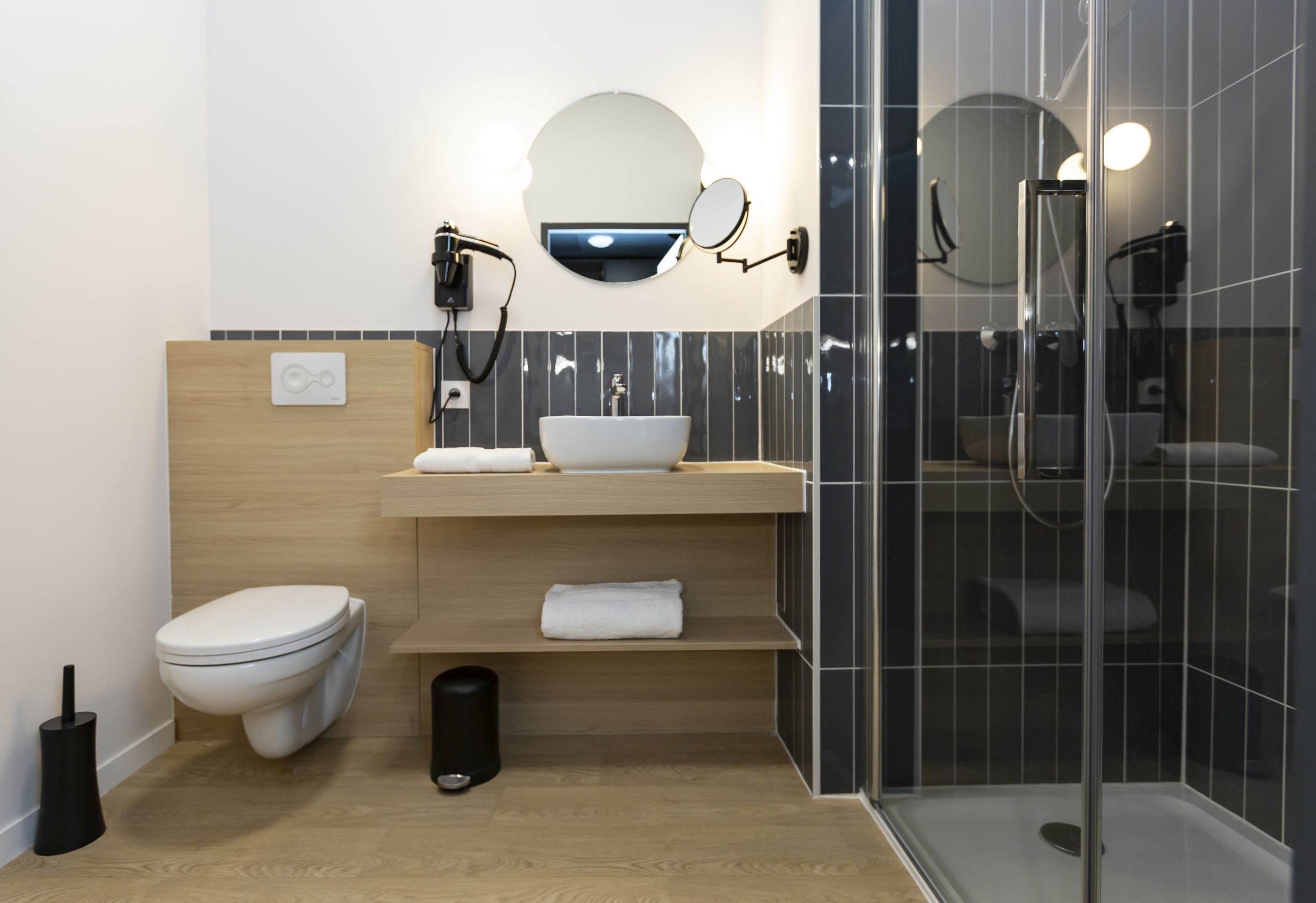 Un baño moderno con inodoro, lavamanos y ducha.
