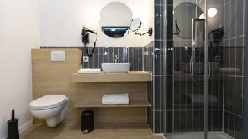 Un baño moderno con inodoro, lavamanos y ducha.