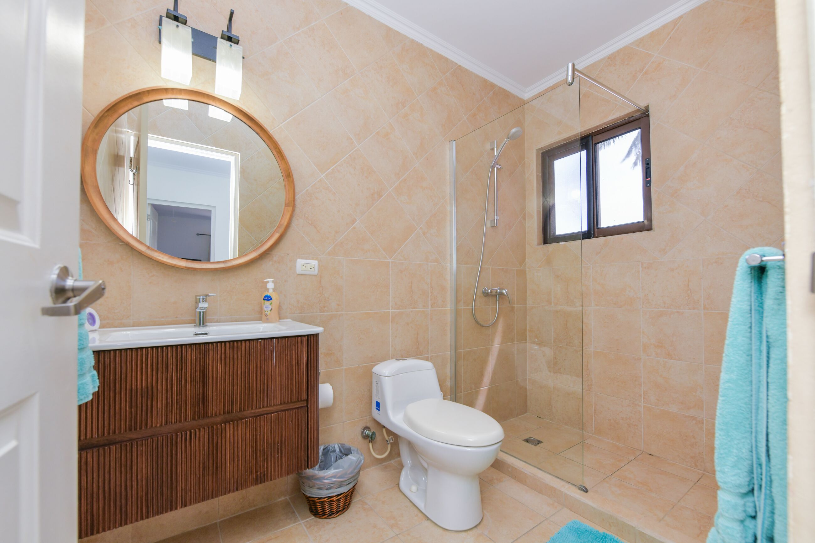 Un baño con inodoro, lavamanos, espejo y ducha.