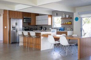 Enjoy cooking in this well-equipped kitchen with a central island, sink, and seating area.