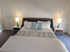 Relax in a spacious room with a large bed, two nightstands, and a lamp on each.