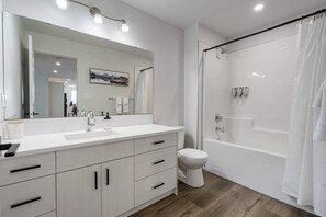 Bathtub, hair dryer, towels, shampoo
