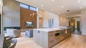 A modern kitchen with a central island, wooden cabinetry, and a built-in oven. - Larkspur Luxe - Northstar- 4 BR w Pool, Gym, Access - Walk to Village. Hot Tub! (Truckee)