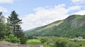 A wooden deck with a view of a green valley and hills. - 3 bedroom accommodation in Aberfoyle (Aberfoyle)
