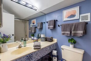 A bathroom with a sink, mirror, towel rack, toilet, and a potted plant. - Sleep 25 - Huge Downtown Vintage Lofts (Chicago)