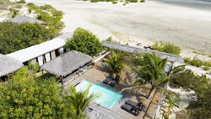 A resort with a pool, thatched-roof structures, and a beach view. - Kitejuba Bungalows (Camocim)