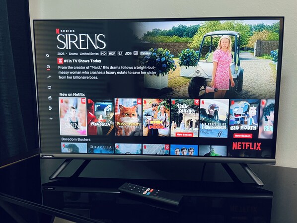 Een televisie waarop een Netflix-interface te zien is met verschillende series en films.
