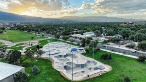 Vue aérienne d’un parc avec des rampes pour le skateboard et une route au premier plan.