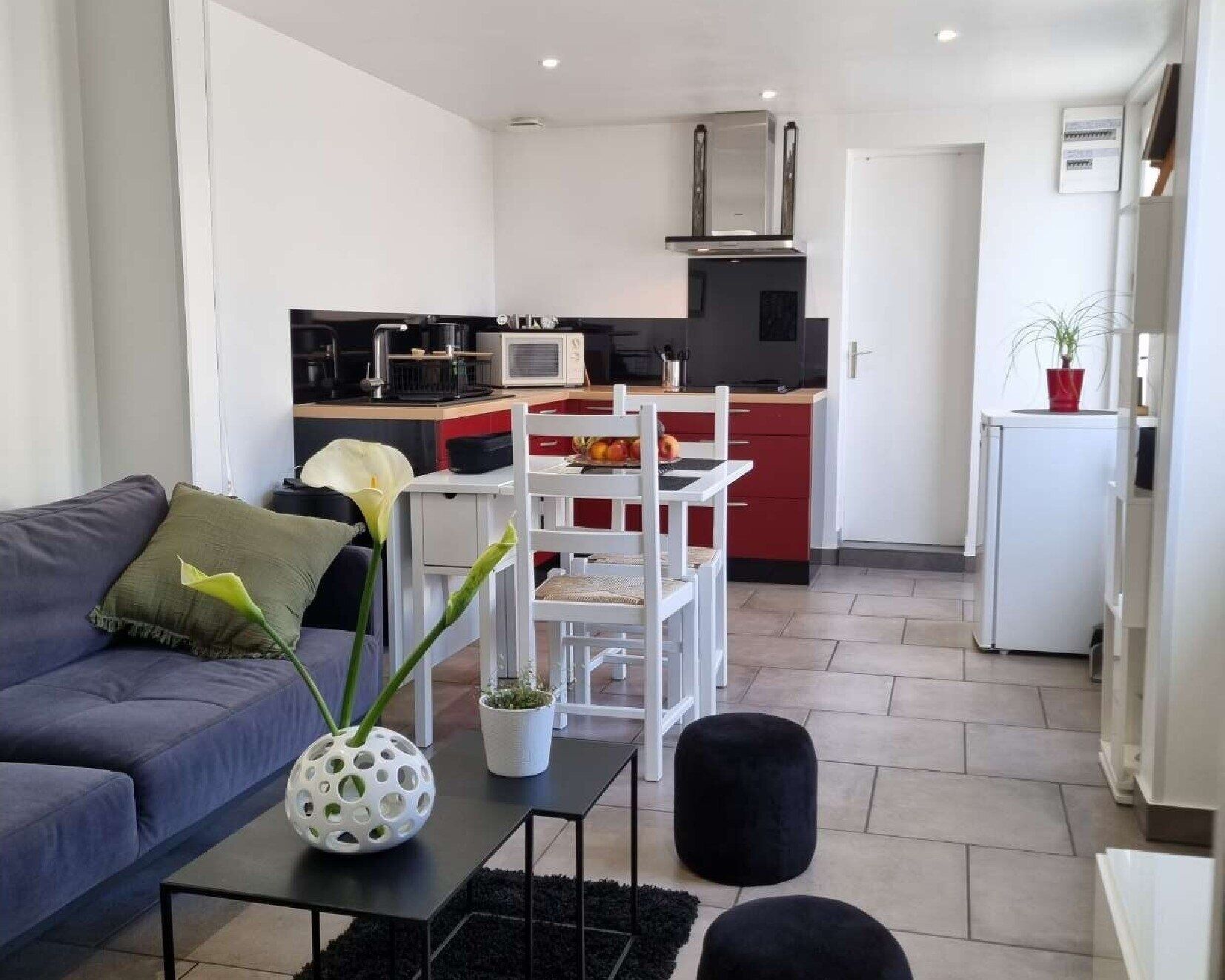 Un salon moderne avec un canapé, une table basse et un petit coin repas.
