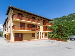 Un hôtel à plusieurs étages doté de balcons, d’un parking et situé dans un cadre montagneux.